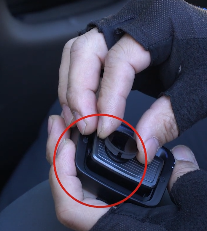 Hands fitting a CPL filter over a THINKWARE dash cam lens