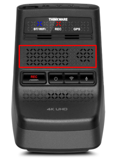 THINKWARE dash cam main unit powered on with status LEDs lit, highlighting the internal speaker grill