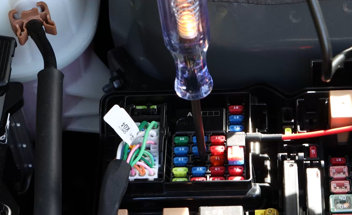 Circuit tester checking power at a vehicle fuse box slot connected to the dash cam Hardwiring Cable